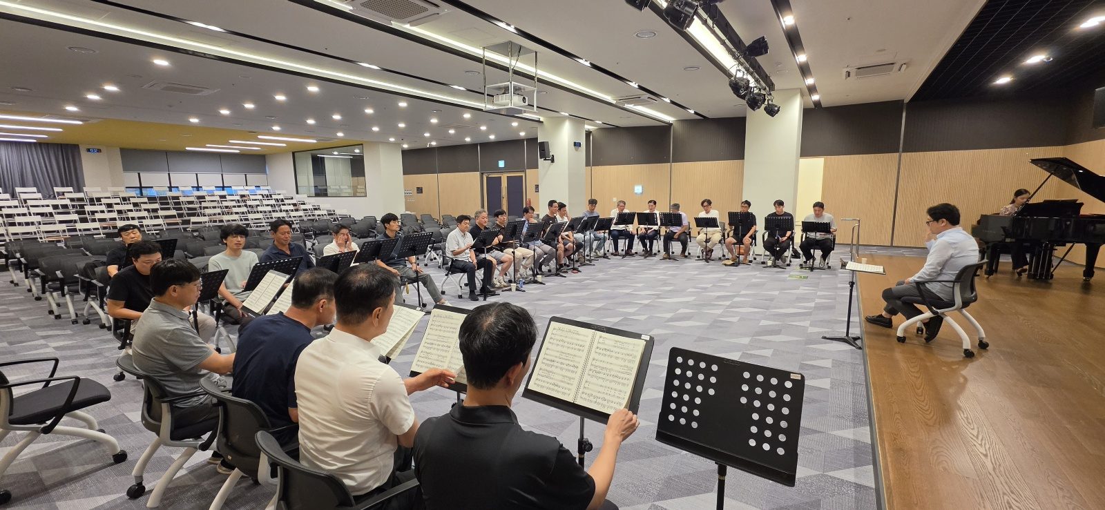 연습홀 전경 — 지휘자를 중심으로 둘러앉은 단원들