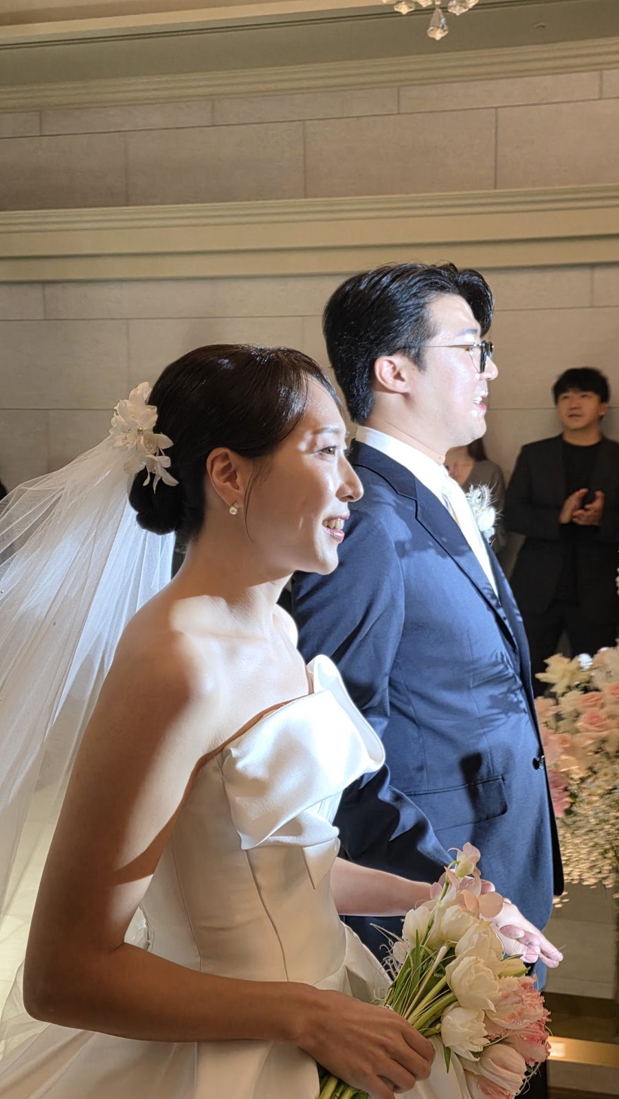 부케를 든 신부와 신랑이 웃으며 걸어가는 모습
